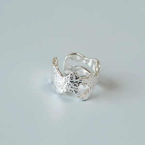 Detail of silver-tone molten texture ring featuring heart cutout and adjustable open band