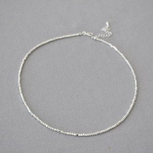 Détail du collier de perles argentées avec perles irrégulières et fermoir mousqueton