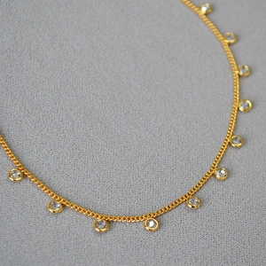 Elegant gold plated brass necklace with bezel set clear crystals in a minimalist style