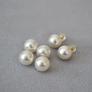 Detailed view of cream faux pearl earrings with 925 silver needles and loose pearls