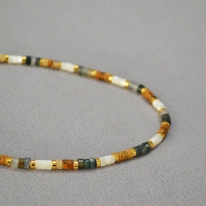 Détail du collier de perles avec nacre et pierres naturelles aux tons terreux