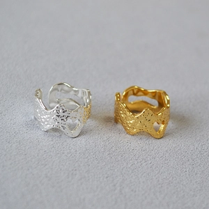 Detail of hammer textured gold and silver rings with unique hollow heart side cutouts