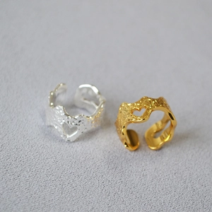 Detail of gold and silver plated open rings with hammered texture and heart cutout design