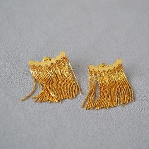 Boucles d'oreilles élégantes à franges dorées avec clous ronds sur velours gris