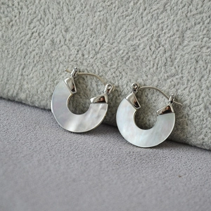 Vue détaillée de boucles d'oreilles fer à cheval en argent avec nacre irisée