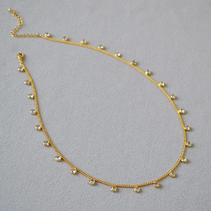 Elegant gold plated choker necklace with shimmering cubic zirconia charms on a dainty chain