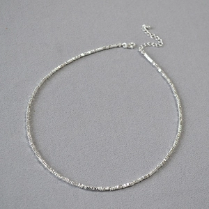 Gros plan détaillé d'un collier ras du cou argenté avec fermoir mousqueton et extension