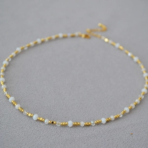 Detail view of handmade beaded brass necklace with gold-plated clasp and colorful beads