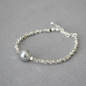 Minimalist silver chain bracelet featuring irregular beads and a large grey pearl