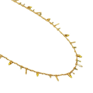 Minimalist gold chain necklace with irregular colorful beads and tassels on white backdrop