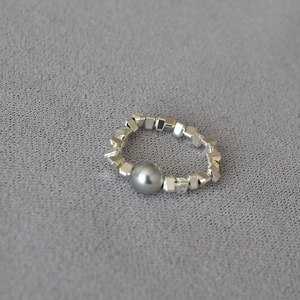 Minimalist silver elastic ring featuring irregular square beads and a grey center pearl