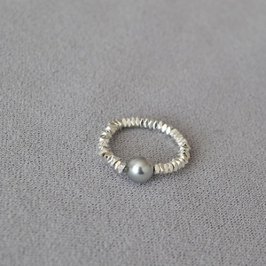 Detail of minimalist elastic ring with silver irregular beads and a grey round pearl