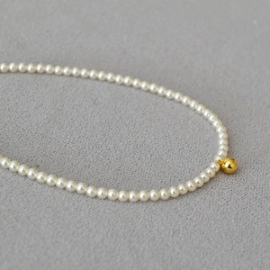 Collier élégant en perles de style français avec pendentif perle dorée sur tissu gris