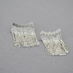 Vue détaillée de boucles d'oreilles argentées à pampilles avec disques et franges