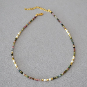 Detail of colorful tourmaline beads and freshwater pearls on a delicate gold clasp chain
