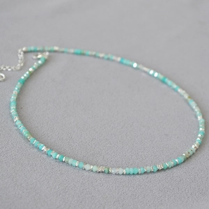 Handmade necklace with faceted green amazonite beads and silver spacers on grey background