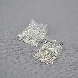 Détail de boucles d'oreilles en argent S925 avec disques en métal et franges de chaînes