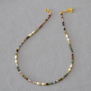 Close-up of tourmaline beads and freshwater pearls necklace with gold lobster clasp