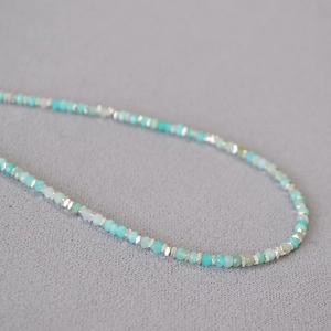 Close-up of green amazonite beads and silver spacers on a minimalist beaded necklace