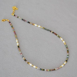 French vintage necklace with colorful tourmaline beads and rice pearls on grey fabric