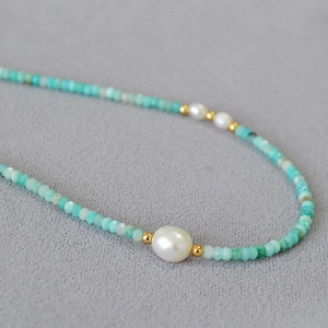 Amazonite beaded necklace with freshwater pearls and gold accents on grey fabric