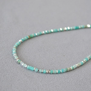 Macro detail of faceted amazonite stone beads and irregular silver spacers necklace
