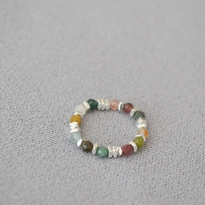 Detail of colorful beaded stretch ring with natural stones and silver hexagonal spacers