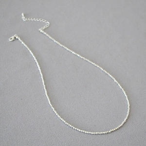 Detail view of silver faceted beaded necklace with lobster clasp and extension chain
