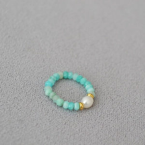 Close-up of beaded ring with blue amazonite stones and a central freshwater pearl