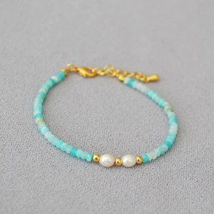 Detail eines Perlenarmbands mit Amazonitperlen, weißen Perlen und Gold-Abstandhaltern