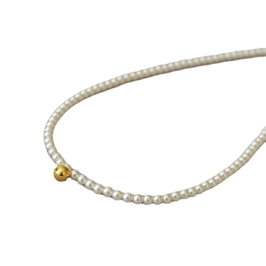 Collier de perles de style français avec perle dorée sur fond blanc pur