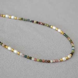 Macro shot of colorful tourmaline beads and freshwater pearls on a vintage necklace