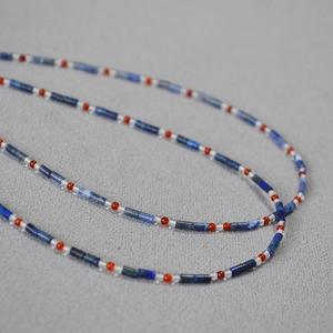Vue macro d'un collier artisanal en perles de lapis-lazuli bleu et pierres d'agate rouge