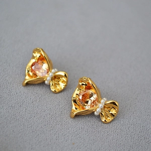 Détails de boucles d'oreilles fleur avec zircon ambre et perles sur métal doré brillant