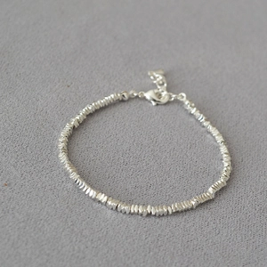 Close-up of sparkling silver beaded bracelet with irregular facets and lobster clasp