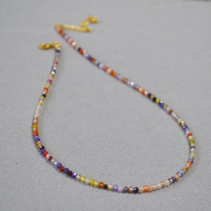 Détail du collier de perles en zircone facettées colorées avec fermoir mousqueton doré