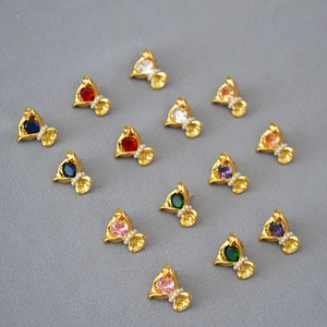 Détail de boucles d'oreilles fleurs en zircon coloré avec perles et base dorée