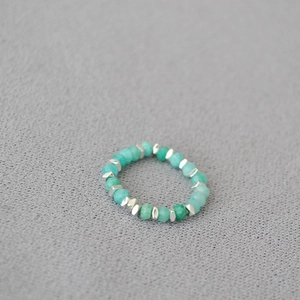 Detailed macro view of faceted amazonite beads and silver spacers on elastic ring