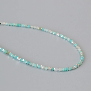 Close-up of minimalist amazonite and silver beaded necklace with fine faceted gemstones