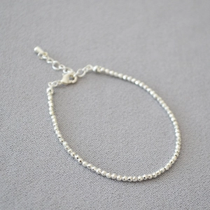 Detail showing faceted silver beaded necklace with adjustable lobster clasp and extension chain