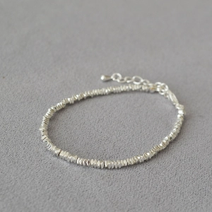 Detailed macro view of multifaceted silver beads and adjustable extension chain