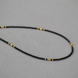 Detailansicht der französischen facettierten schwarzen Spinellkette mit Goldperlen