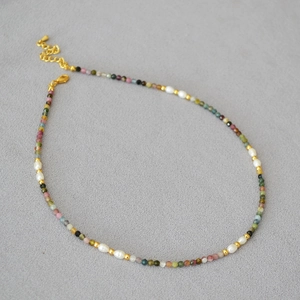 Close-up of tourmaline beads and freshwater pearls necklace with gold lobster clasp