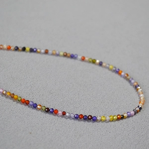 Détail d'un collier de perles en zircon facettées colorées avec petites perles