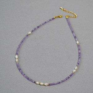 Detailed view of lavender amethyst beads and white freshwater pearls with golden clasp