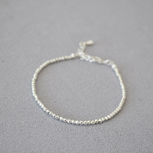 Detailed view of faceted silver beads on an adjustable necklace with lobster clasp