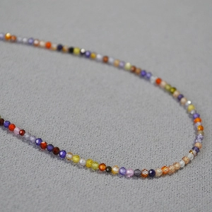 Vue macro d'un collier de perles en zircon facetté coloré avec surface réfléchissante