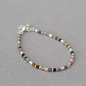 Makroaufnahme von buntem Turmalin-Perlenarmband mit silbernen Zwischenperlen