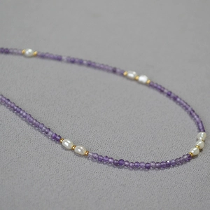 Detail of amethyst beads mixed with baroque pearls and gold spacers on a minimal necklace