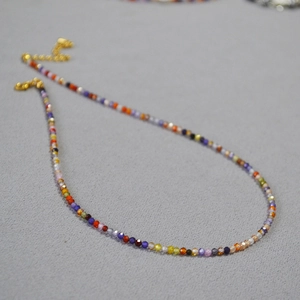 Détail de perles de zircon colorées avec fermoir mousqueton doré et chaîne réglable
